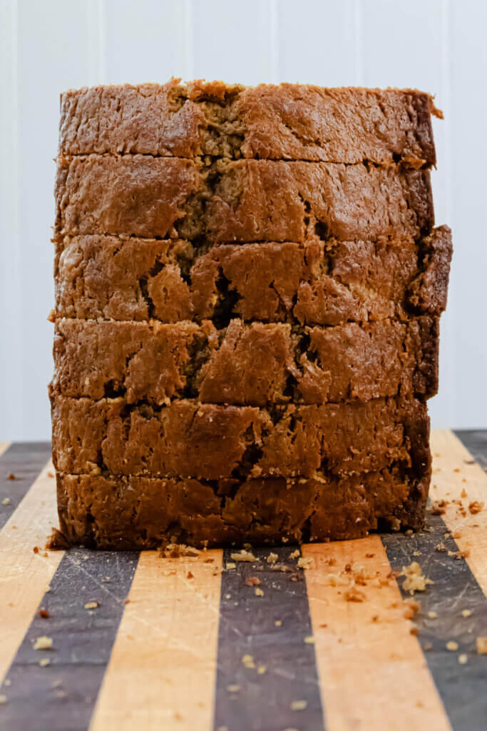 stacked loaf of banana bread with brown sugar on a wooden cutting board