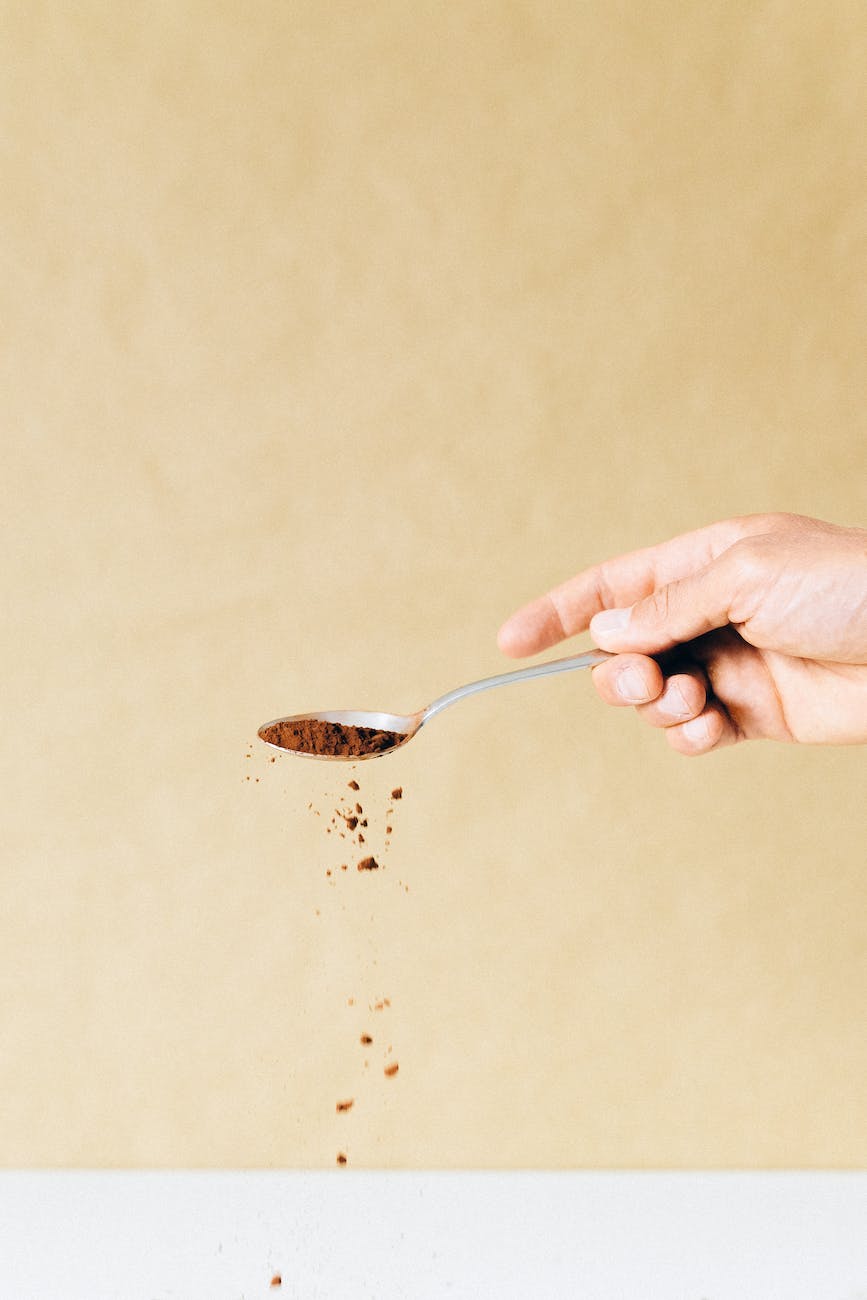 a person holding a stainless spoon with powder