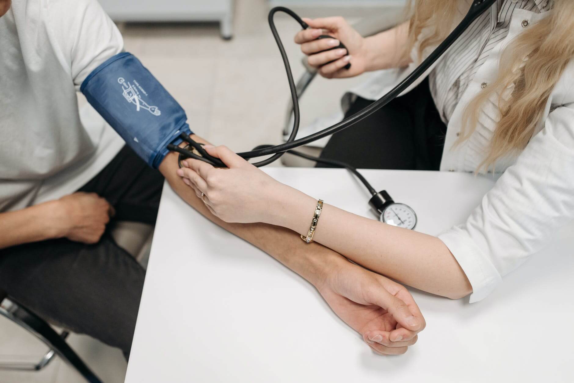a healthcare worker measuring a patients blood pressure using a sphygmomanometer